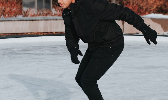 man in black jacket ice skating